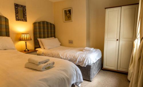 a bedroom with two beds with towels on them at Millbrae Townhouse in Buncrana