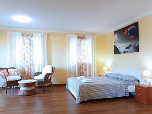 オロペサ・デル・マールにあるVilla con piscinaのベッドルーム1室(ベッド1台、椅子2脚付)