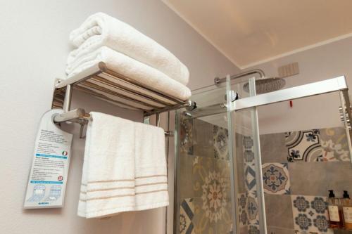 a bathroom with a shower and towels on a rack at Er Mirin - Il Mulino di Carcare Hotel in Carcare