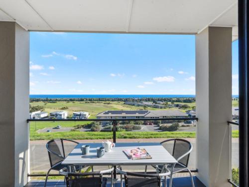 a table and chairs on a balcony with a view at 18 Turnberry Drive in Normanville