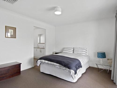 biała sypialnia z łóżkiem i stołem w obiekcie Beach Fun 11 Broadbeach Drive w mieście Carrickalinga