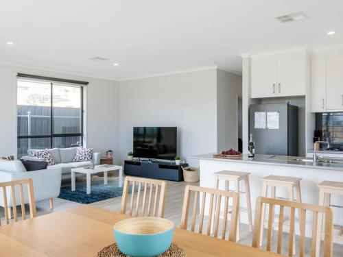 Una cocina y una sala de estar con mesa y sillas. en Putters Paradise 25-30 Troon Drive, en Normanville