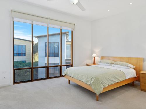 a bedroom with a bed and a large window at South Shores Villa 59 in Normanville