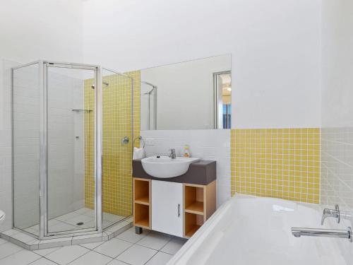 a bathroom with a tub and a sink and a shower at South Shores Villa 59 in Normanville