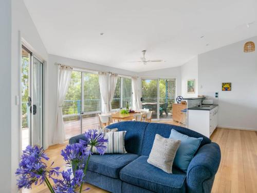 a living room with a blue couch and a kitchen at Seven on Scenic - 7 Scenic View Drive, Second Valley in Second Valley