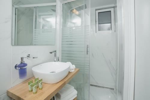 a white bathroom with a sink and a shower at Acropolis Vision in Athens