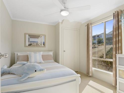 a white bedroom with a shark pillow on the bed at Carried Away 9 Dorset Court in Carrickalinga