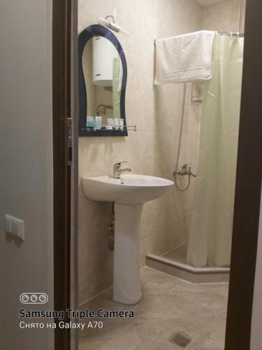 a bathroom with a sink and a shower with a mirror at Квартира у моря Колхида in Makhinjauri
