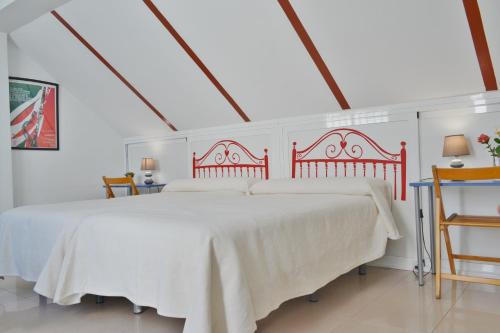 a bedroom with a large white bed with a red headboard at SunShine Villa in Córdoba