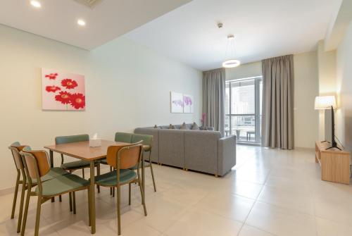 a living room with a table and chairs and a couch at Grand Stay Holiday Homes Rental in Dubai