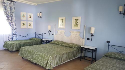 2 camas en un dormitorio con paredes azules en iGV Club Vacanze Le Castella, en Le Castella