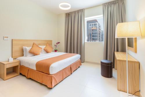 a hotel room with a bed and a window at Grand Stay Holiday Homes Rental in Dubai