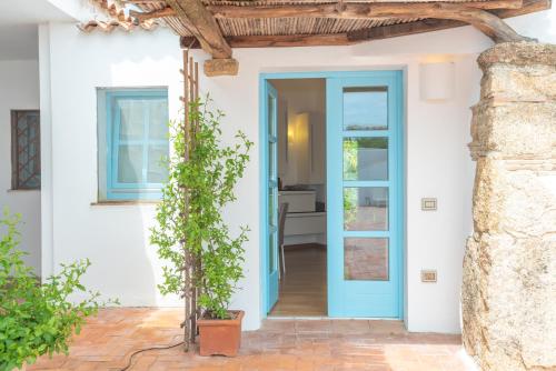 une porte bleue sur une maison blanche dans l'établissement Cozy apartment Lemon San Pantaleo, à Olbia