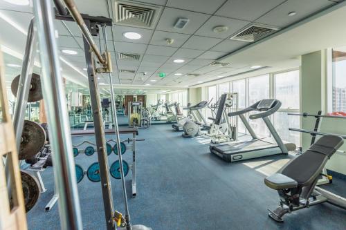 a gym with cardio equipment and treadmills at Grand Stay Holiday Homes Rental in Dubai