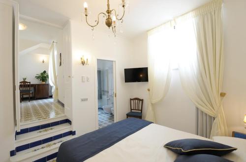 a bedroom with a large bed and a bathroom at Boutique Gimagì in Amalfi
