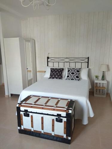a bedroom with a bed with a black and white comforter at Apartamento La Placeta in Monroyo