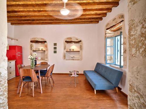 a living room with a blue couch and a table at Kambos House in Kimolos