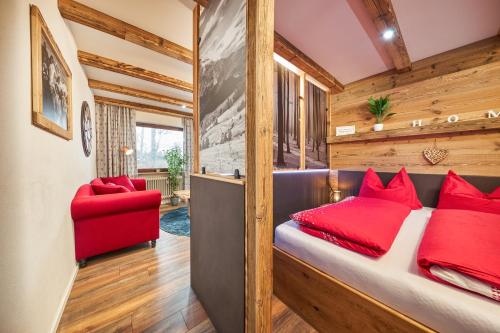 una camera con un letto rosso e una sedia rossa di Landhotelwohnung in Seeg a Seeg