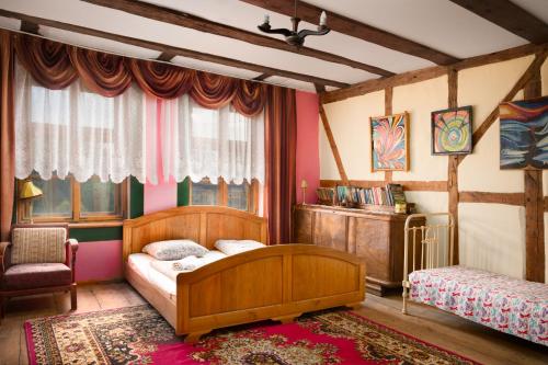 ein Schlafzimmer mit einem Bett und einem Stuhl in einem Zimmer in der Unterkunft Zagroda Chłopska in Gosław