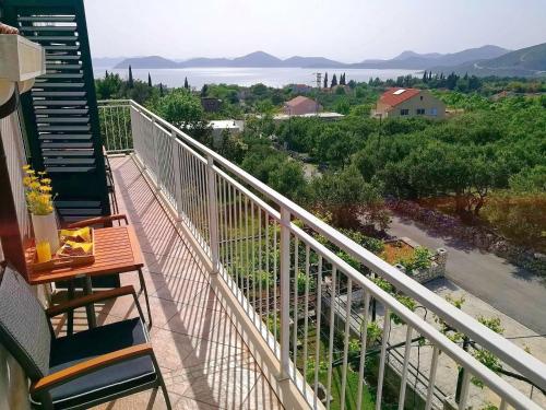 een balkon met uitzicht op het water en de bergen bij Apartments Kola in Banići