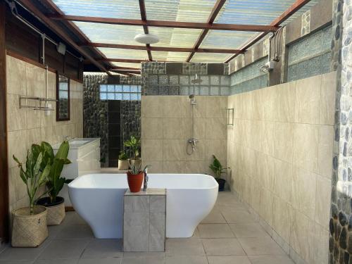uma casa de banho com uma banheira, um chuveiro e um lavatório. em Compass Atauro Eco Lodge em Beloi