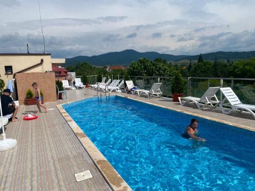 a man is sitting in a swimming pool at Fantasy Apartment 15 комплекс Фантазия, Хисаря in Hisarya