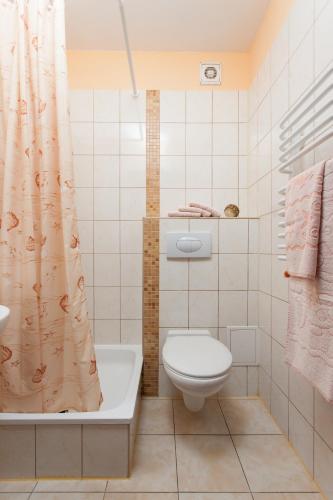 a bathroom with a toilet and a shower curtain at Dom Gościnny Emilia in Pobierowo