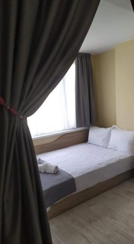 a bed in a room with a window at Family Hotel Malibu in Chernomorets