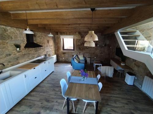 una cucina e una sala da pranzo con tavolo e sedie di O RINCÓN DE NOAH a Finisterre