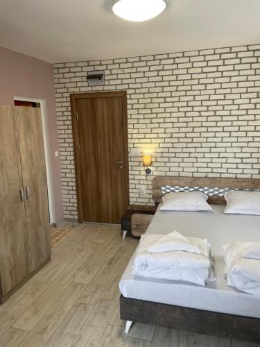 a bedroom with two beds and a brick wall at Family Hotel Malibu in Chernomorets