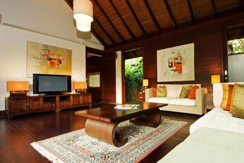 a living room with a couch and a tv at Gending Kedis Luxury Villas & Spa Estate in Jimbaran