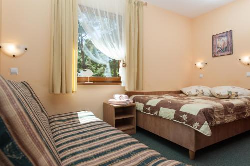 a hotel room with two beds and a window at Dom Gościnny Emilia in Pobierowo