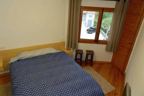 Guesthouse "La Gloria de Arbolí" في Arboli: غرفة نوم بسرير ازرق ونافذة