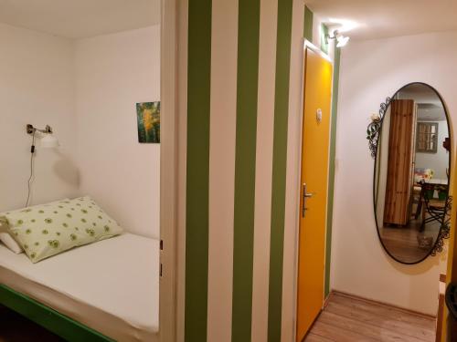 um pequeno quarto com uma cama e um espelho em Charismatic Garden Cottage with Sea View em Lokva Rogoznica