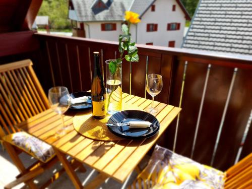 a wooden table with plates and glasses on a balcony at Juliana Apartment Bohinj Lake in Bohinj