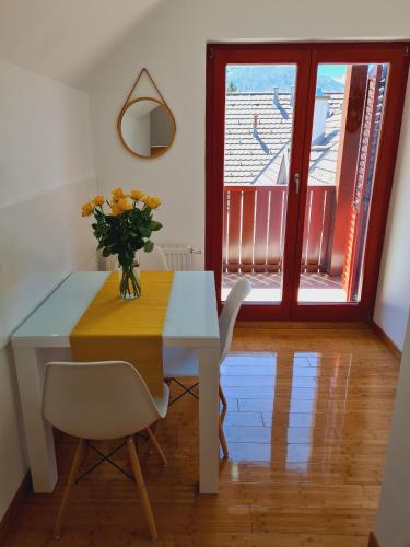 a dining room table with a vase of flowers on it at Juliana Apartment Bohinj Lake in Bohinj