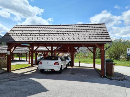a car parked in a parking lot with a roof at Juliana Apartment Bohinj Lake in Bohinj
