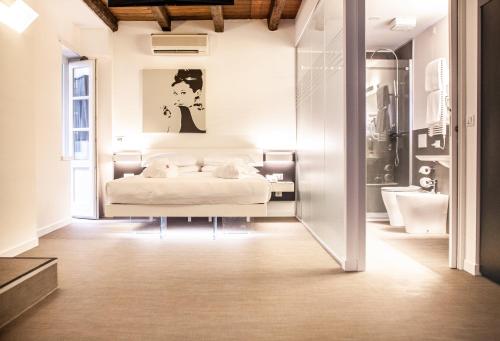 1 Schlafzimmer mit einem weißen Bett und einem Badezimmer in der Unterkunft Urban Hotel Design in Triest