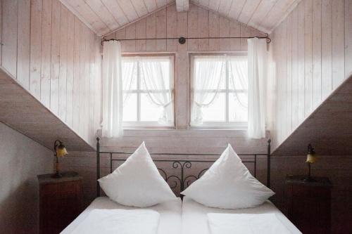 1 Schlafzimmer mit einem Bett mit weißer Bettwäsche und 2 Fenstern in der Unterkunft Kaffeehaus Blaslhöhe in Lam