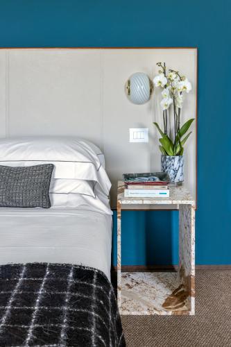 a bedroom with a bed and a table with a vase of flowers at 4F Boutique Hotel Florence in Florence