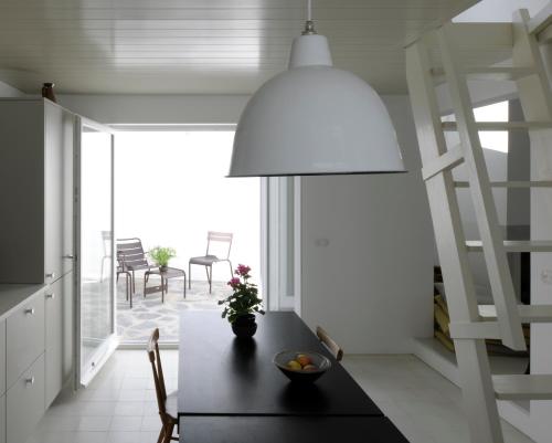 a dining room with a table and a large lamp at Centric Townhouse CADAQUÉS - Casa Voltes - in Cadaqués
