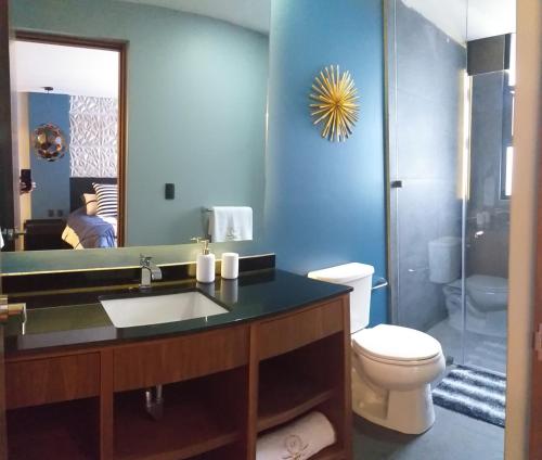 a bathroom with a sink and a toilet and a mirror at Business SUITES KEPLER in Mexico City