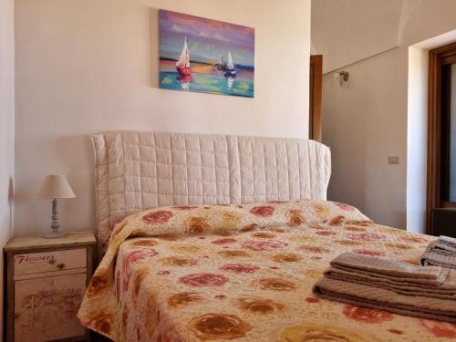 a bedroom with a bed and a painting on the wall at Dammuso Il tramonto di Nica' in Scauri