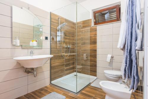 uma casa de banho com um chuveiro, um lavatório e um WC. em Apartman Chiara em Rijeka