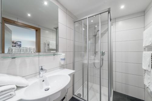 a white bathroom with a sink and a shower at Apart Hotel Garni Wieser in Sölden
