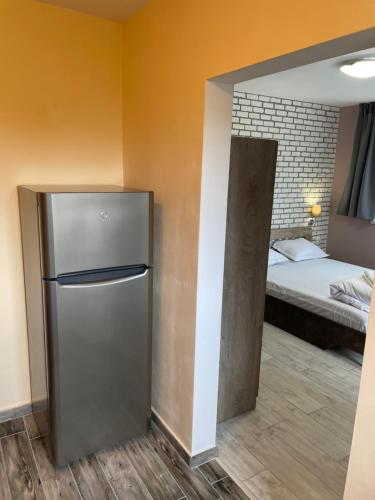 a small refrigerator in a room with a bed at Family Hotel Malibu in Chernomorets