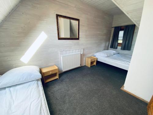 um quarto com duas camas e um espelho na parede em Tatarak domki na mazurach nad jeziorem Wałpusz em Stare Kiejkuty