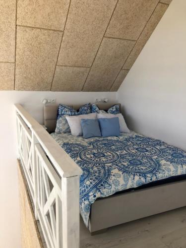 a bedroom with a bed with blue and white sheets at Domek z jacuzzi Summer House Dziwnówek Wrzosowo in Wrzosowo