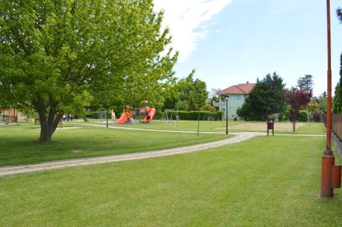 a park with people playing on a playground at Mediterán Fedett Medencés Apartmanház in Szántód