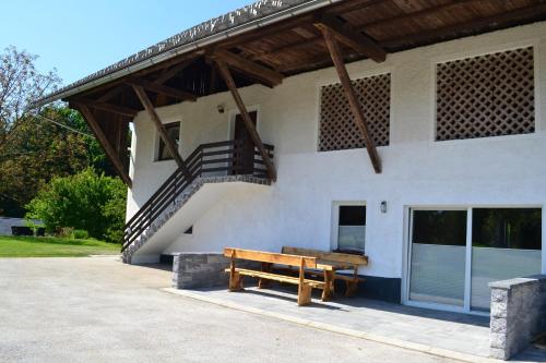 a wooden bench sitting in front of a building at Small wooden houses and Apartments Zgornja Dobrava in Radovljica